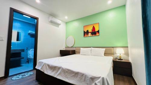 a bedroom with a large white bed and a bathroom at Chippi villa in Ha Long