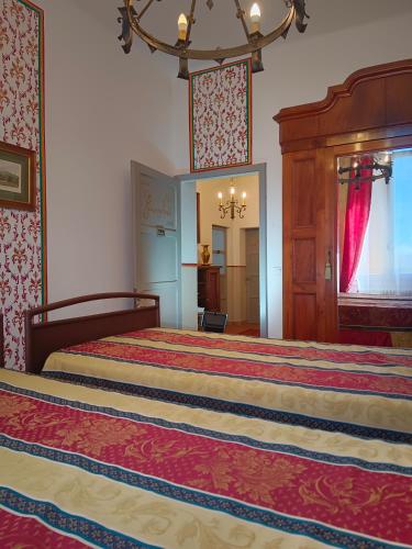 a large bedroom with two beds and a chandelier at La Maison Rouge in Crespellano