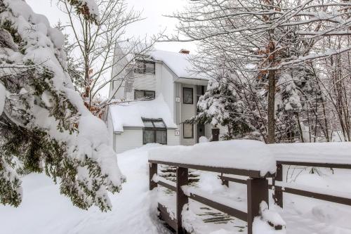 un cortile coperto da neve con recinzione e casa di Sunrise Mountain Village a Killington