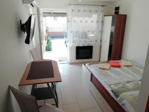 um quarto com uma cama, uma mesa e uma secretária em Zseli Apartmanház em Siófok