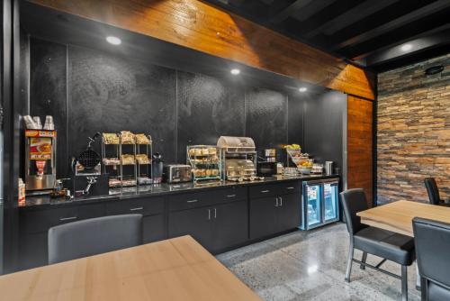 a restaurant with a counter with tables and chairs at Cobblestone Hotel & Suites - Cullman in Cullman