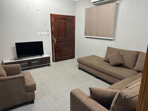 a living room with a couch and a flat screen tv at الجوار in Al Madinah