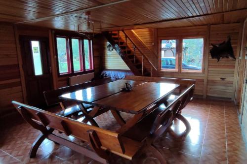 uma sala de jantar em madeira com uma mesa de madeira e escadas em Moonlight Chalet Brasov em Codlea