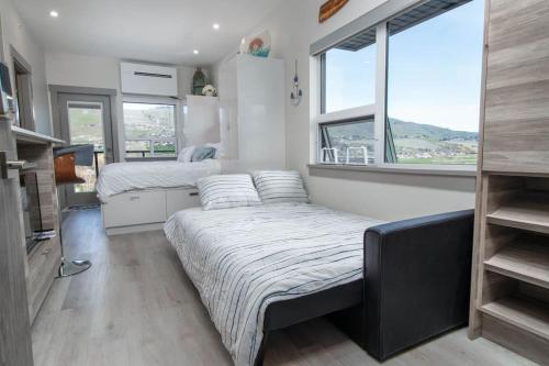 a bedroom with two beds and two windows at Top Floor Okanagan Lake Condo W Pool, Views in Vernon