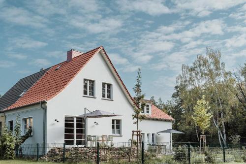 Casa blanca con techo rojo en Spreewaldhaus am Landgut - Das Haupthaus, en Markische Heide