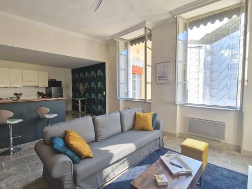 een woonkamer met een bank en een tafel bij L'appartement des Arènes - Nîmes in Nîmes