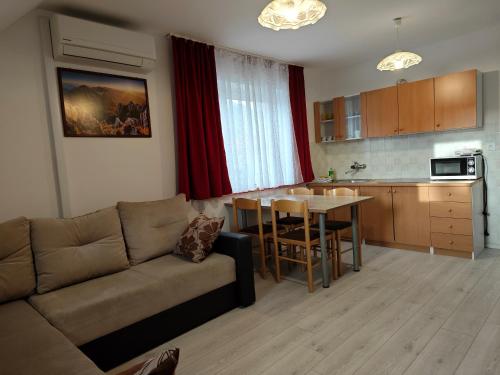 un soggiorno con divano e tavolo e una cucina di Apartmaji Pri Kokolu a Bled