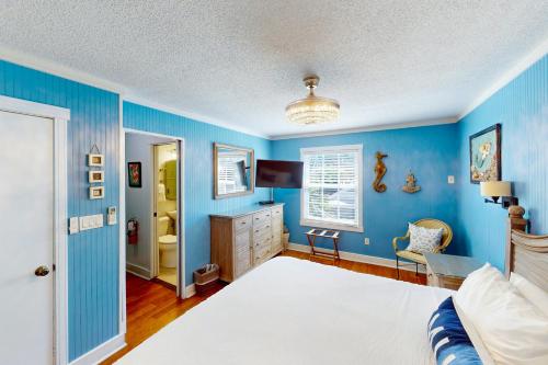 Dormitorio azul con cama y escritorio en Old Town Garden Villas - Andros Suite, en Key West