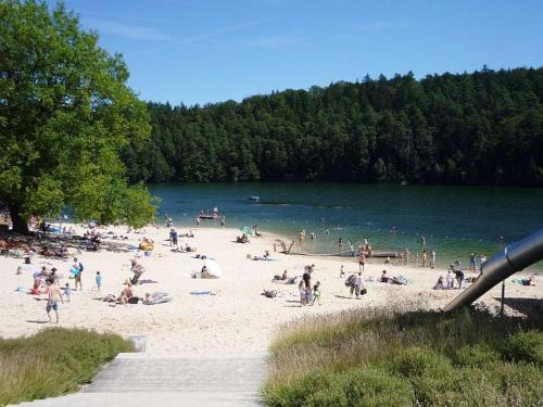 un gruppo di persone su una spiaggia vicino a un lago di Schönes Ferienhaus am Twistesee - b62252 a Bad Arolsen