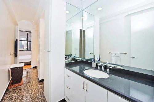 a bathroom with a sink and a large mirror at Amazing 1300sf Loft By Union Sq in New York