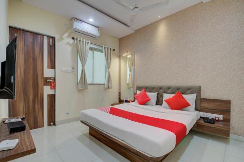 a bedroom with a large bed with red pillows at Hotel Sunshine Near Inox in Pune