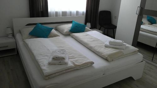 een wit bed met handdoeken en kussens erop bij Bora Appartements 1 mit 4 Schlafzimmer in Zell am See