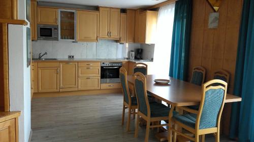 een keuken met houten kasten en een houten tafel en stoelen bij Bora Appartements 1 mit 4 Schlafzimmer in Zell am See