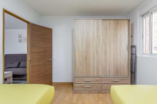 a bedroom with a large wooden cabinet and a bed at Apartamento 3 habs Madrid in Madrid