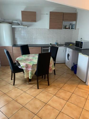 a kitchen with a table and chairs and a kitchen with a stove at La Pause in Lormont