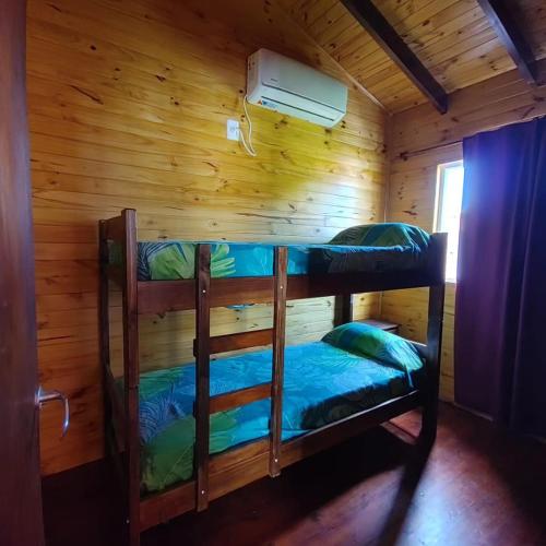 a room with two bunk beds in a cabin at Cabaña Las Martinetas in María Grande