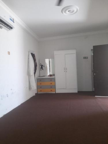 una stanza vuota con un comò e un muro bianco di بيت او منزل للإيجار اليومي والاسبوعي في جعلان بو علي a Al Bulaydah