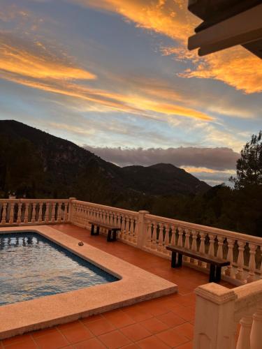 a swimming pool on a balcony with a sunset at Casa Luna in La Drova