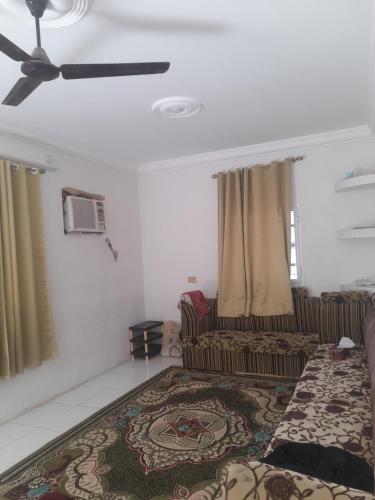 un soggiorno con divano e ventilatore a soffitto di بيت او منزل للإيجار اليومي والاسبوعي في جعلان بو علي a Al Bulaydah