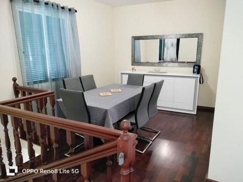 a dining room with a table and chairs and a mirror at casa sousa in Campanário