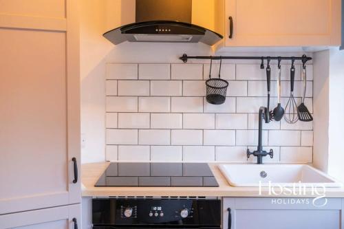 a kitchen with a sink and a stove at Stylish 2 Bedroom Apartment Close To The River & Station in Henley on Thames