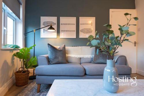 a living room with a blue couch and a table at Stylish 2 Bedroom Apartment Close To The River & Station in Henley on Thames