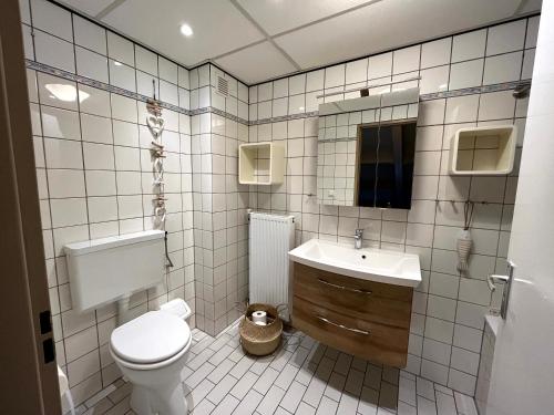 a white bathroom with a toilet and a sink at Ferienhaus CARPE DIEM Schoneveld - Breskens - Urlaub mit Hund in Breskens