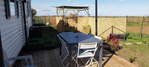 einen Tisch und zwei Stühle auf einer Terrasse mit einem Zaun in der Unterkunft Chez Elvis et Agnès 
