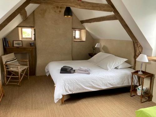 Un dormitorio con una cama blanca con una mochila. en Le Pas Saint Joseph, en Saint-Malo