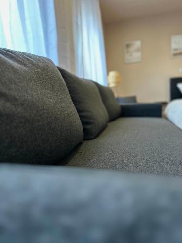 a couch sitting in a living room next to a window at Modernes Apartment am Dreiländereck in Alsdorf