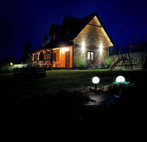 a house with two lights in the yard at night at Domek pod Dębami Bogaczewo in Bogaczewo