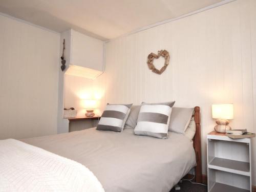 a bedroom with a white bed with pillows and two lamps at 2 Bed in Bude NPHON in Poundstock