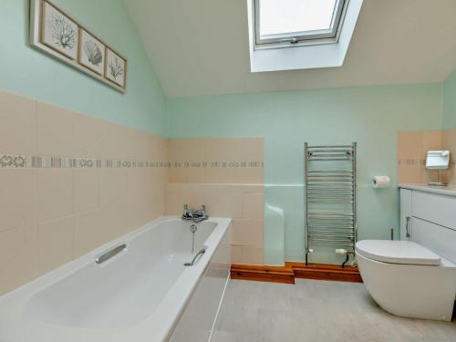 a bathroom with a tub and a toilet and a window at 2 Bed in South Molton 3.1 miles SE 91154 in George Nympton