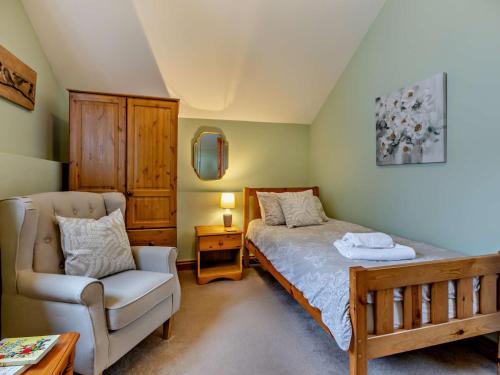 a bedroom with a bed and a chair at 2 Bed in South Molton 3.1 miles SE 91154 in George Nympton