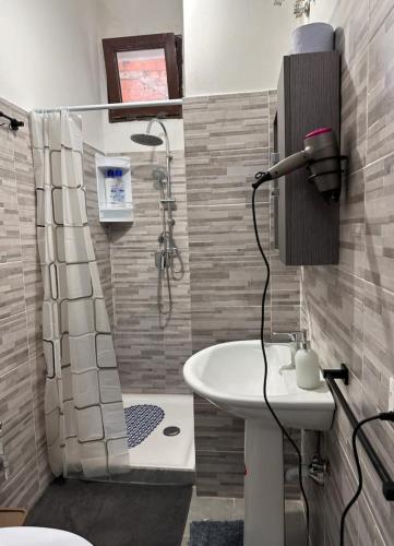La salle de bains est pourvue d'un lavabo, d'une douche et de toilettes. dans l'établissement Marrakech rooms 3, à Catane