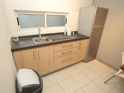 a small kitchen with a sink and a refrigerator at De Triana Hotel in Rancagua