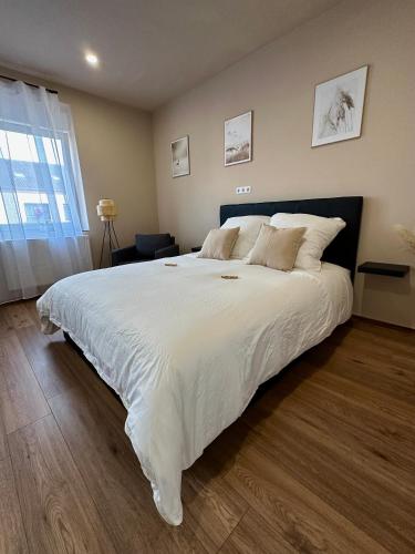 1 dormitorio con 1 cama grande con sábanas blancas en Modernes Apartment am Dreiländereck, en Alsdorf