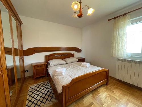 a bedroom with a bed in a room with a window at Apartman Ana in Rijeka