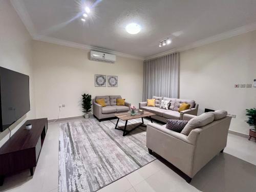a living room with two couches and a flat screen tv at شقق نسج المسكن دخول ذاتي شمال الرياض in Riyadh