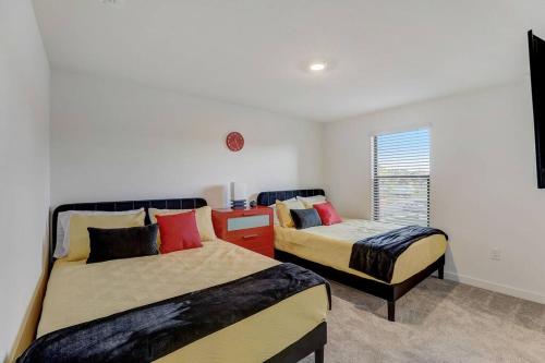 a bedroom with two beds and a desk at Kissimmee Modern 3BR Home With a pool & Close to Beach in Kissimmee