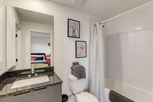 a bathroom with a toilet and a sink and a mirror at Kissimmee Modern 3BR Home With a pool & Close to Beach in Kissimmee