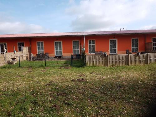 an orange house with a fence in front of it at Ein Hauch von Orient in Eggesin