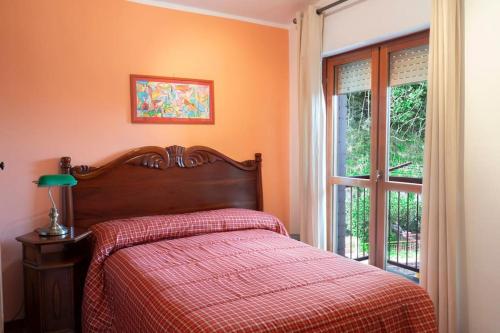 a bedroom with a bed with a red blanket and a window at Casa Silvana in Vico Equense