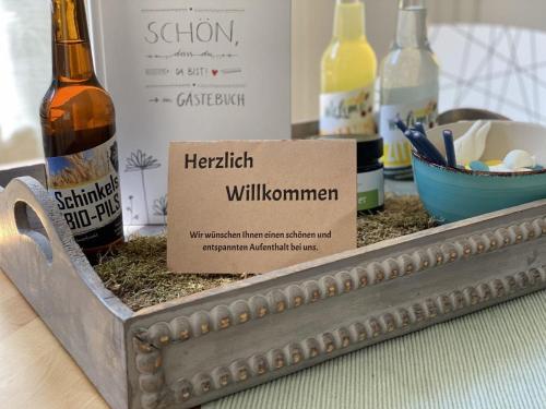 bandeja de metal con una botella de alcohol y una señal en Der Bauerngarten, en Hofgeismar
