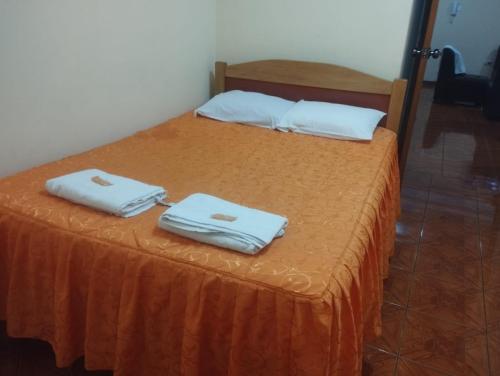 2 camas con toallas blancas encima en Departamento amoblado Santa Beatriz, en Tacna
