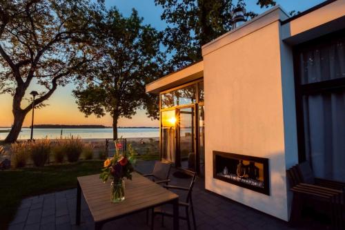 a vase of flowers on a table on a patio at Exclusive Cube mit Meerblick direkt am Strand Strandhaus in Hulshorst