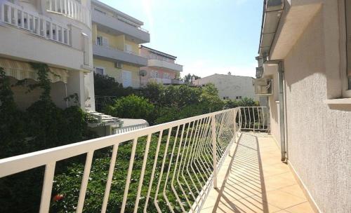 - un balcon avec une balustrade blanche à côté d'un bâtiment dans l'établissement Schöne Ferienwohnung in Baška Voda mit Garten, à Baška Voda