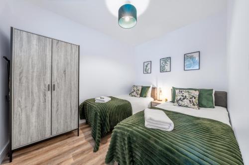 a bedroom with two beds and a closet at Modern 2 bed in Potters Bar - with FREE Parking- 4 min walk from the TRAIN STATION - DIRECT TRAINS TO LONDON in Potters Bar