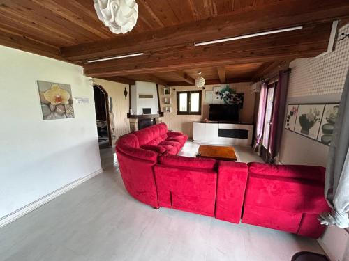 un soggiorno con divano rosso in una camera di La Kaz du Volcan-Capacité maximum 10 personnes a La Plaine des Cafres