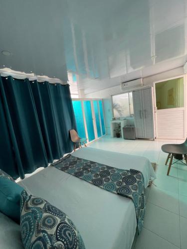 a bedroom with two beds and blue curtains at Posada Sunrise View in Providencia